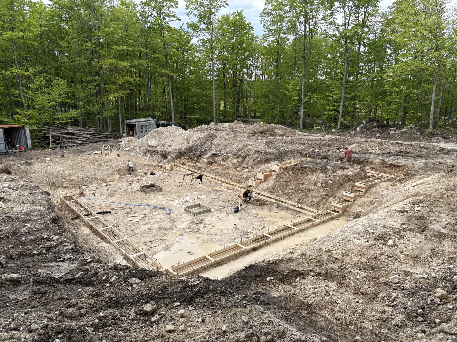 Excavated building site in the woods with footing forms set for a new foundation
