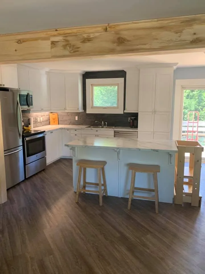 Renovated kitchen with white cabinets and island by CKThompson Contracting