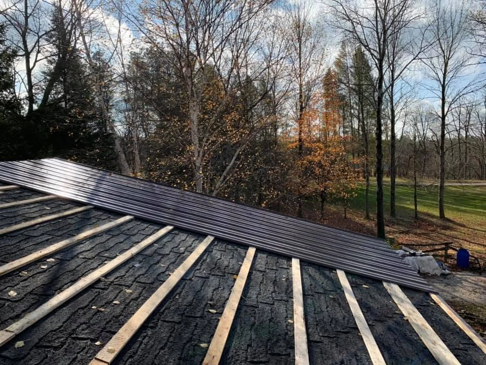 Steel roofing panels being installed on a home by CKThompson Contracting